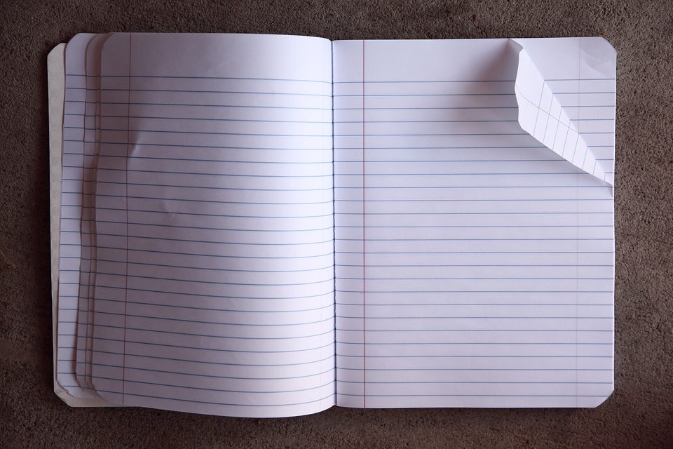 An open notebook left with a pencil across the page