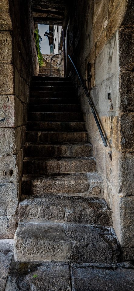 Stone steps worn hollow: not by one crossing, but by the same one repeated